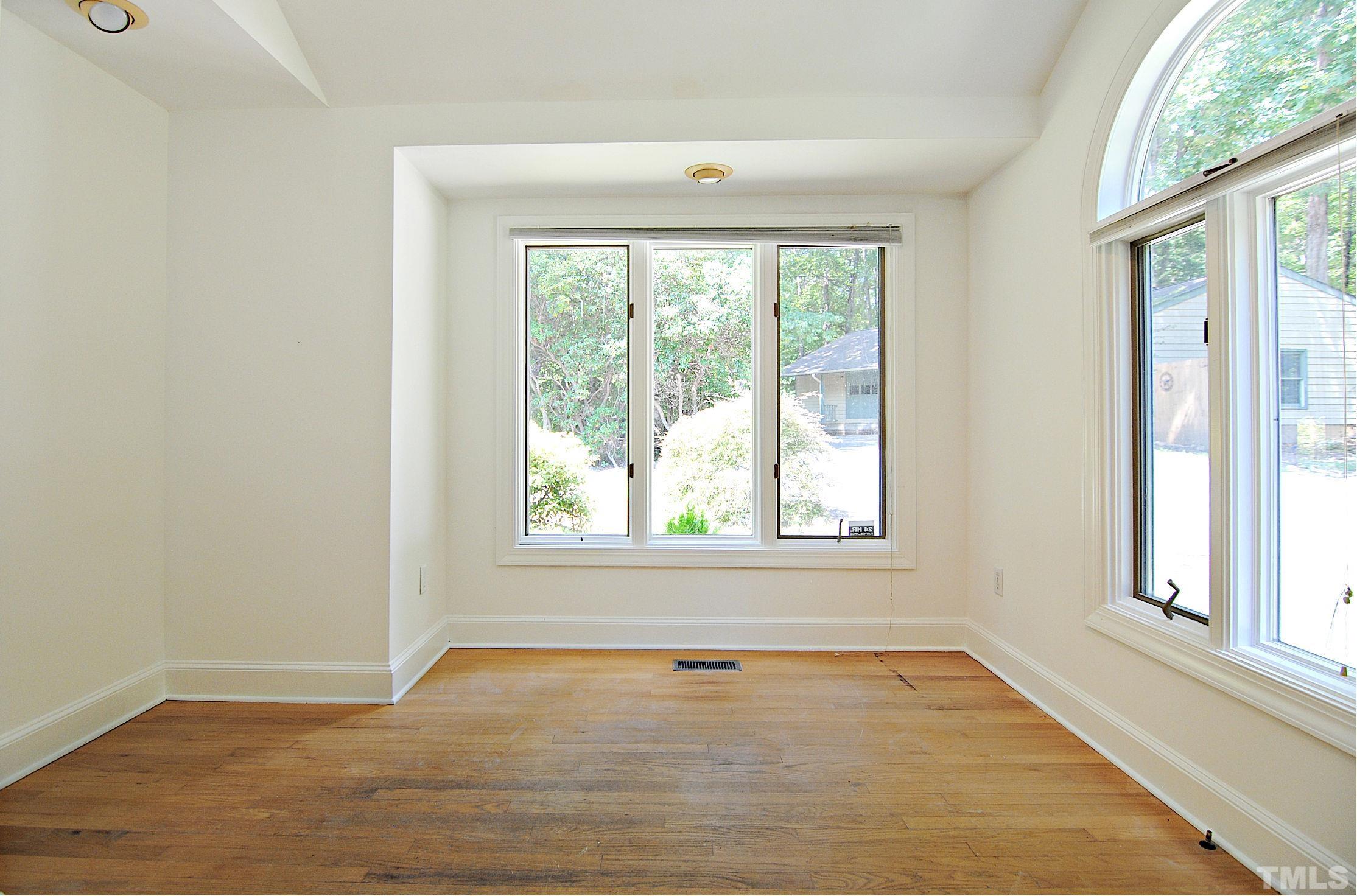 7106 Matthews Road Durham, NC 27712 - Photo 14 of 30 an empty room with wooden floor and windows