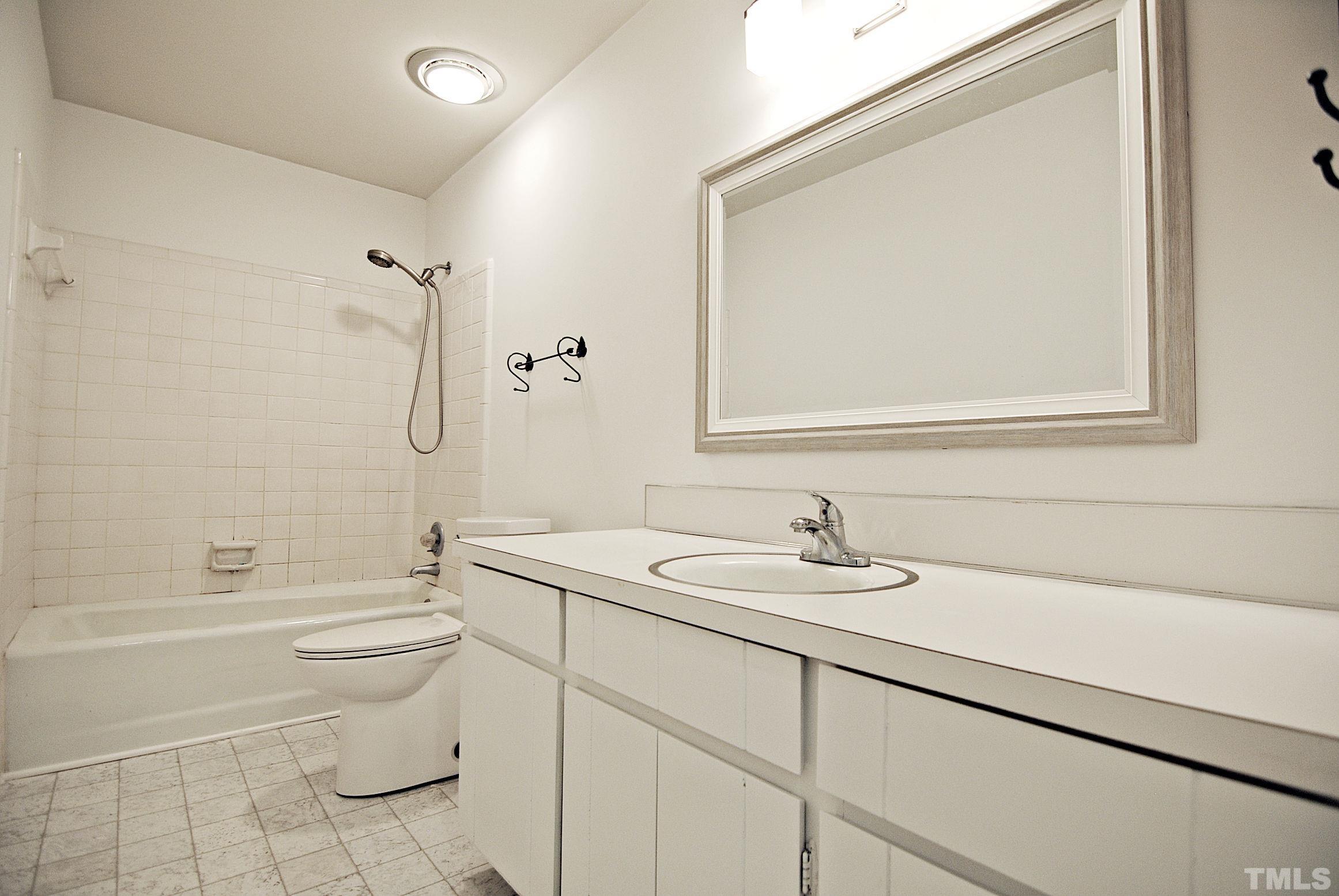 7106 Matthews Road Durham, NC 27712 - Photo 17 of 30 a bathroom with a granite countertop sink toilet and shower
