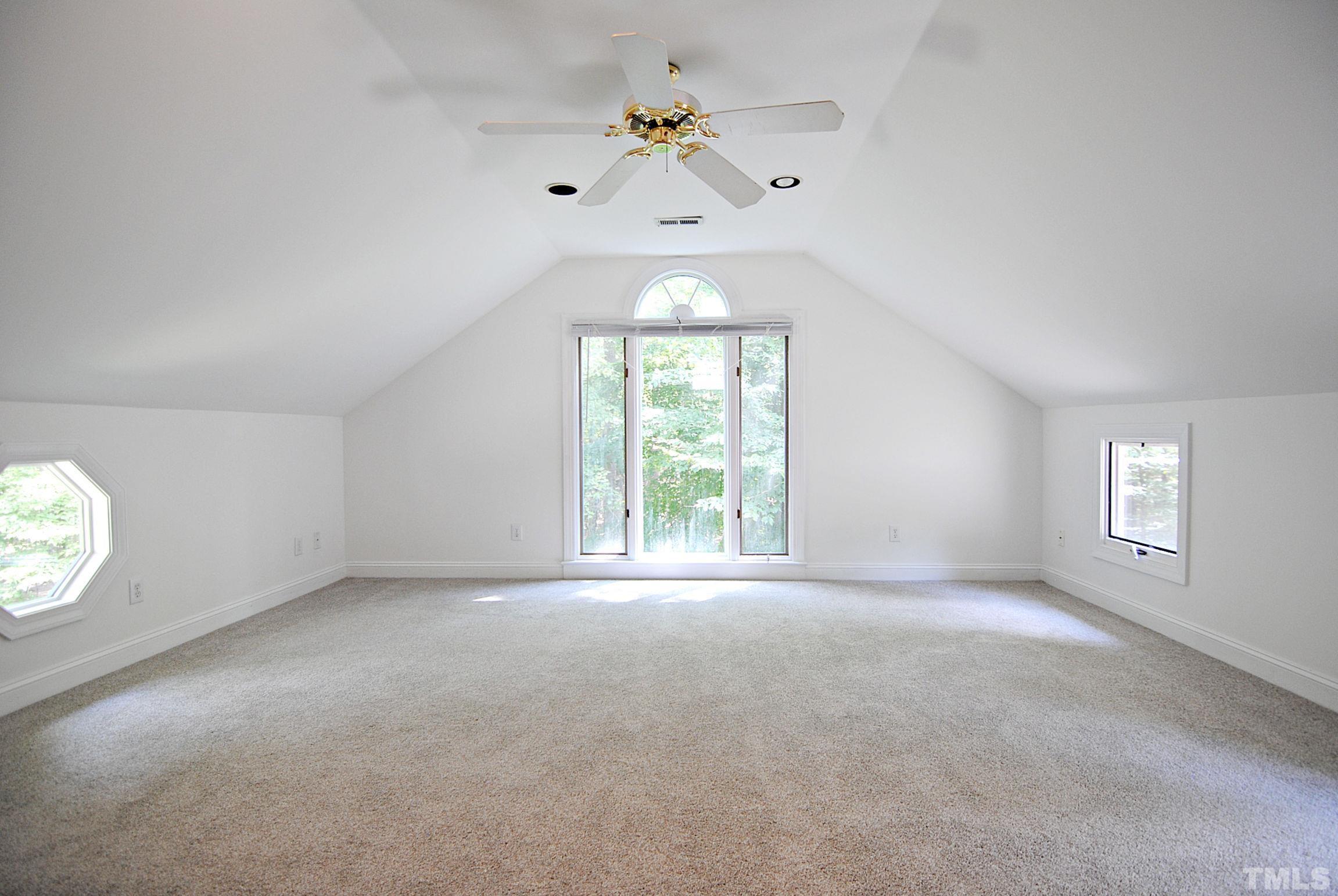 7106 Matthews Road Durham, NC 27712 - Photo 20 of 30 an empty room with windows and chandelier fan