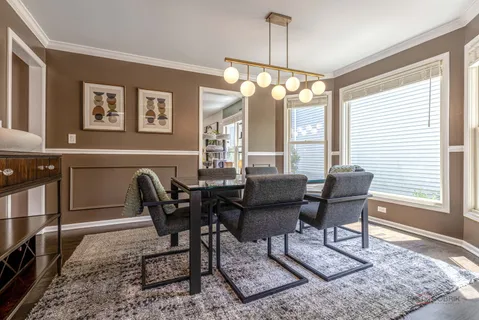 a dining room with furniture a chandelier and wooden floor