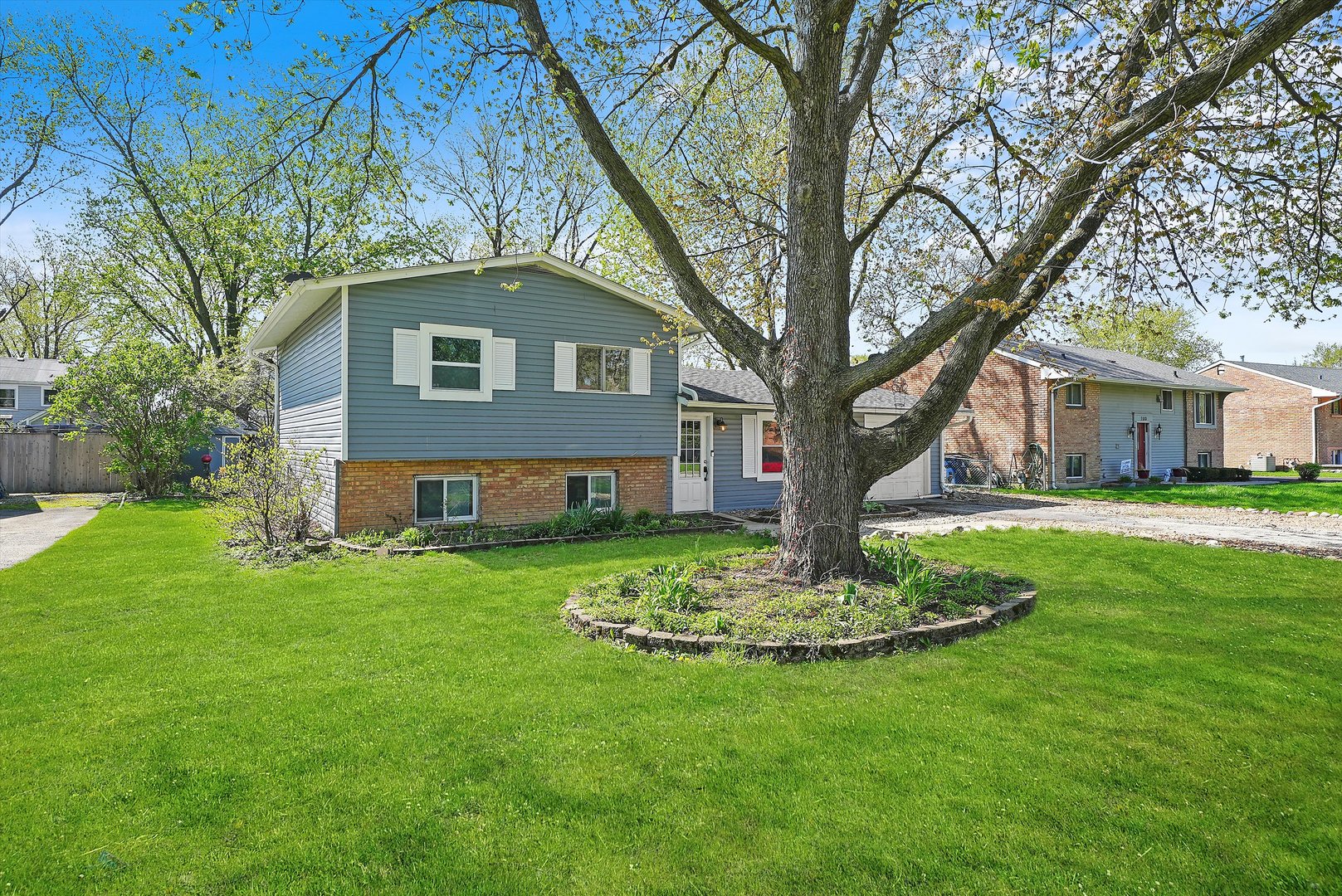 176 Oxford Road Bolingbrook, IL 60440 - Photo 4 of 43 a front view of a house with a garden and trees