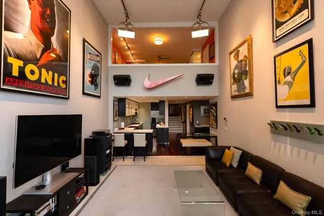 a living room with furniture a flat screen tv and kitchen view