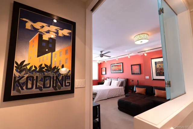 a spacious bedroom with a bed and ceiling fan