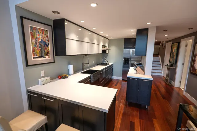 a kitchen with stainless steel appliances kitchen island granite countertop a stove a sink and a refrigerator
