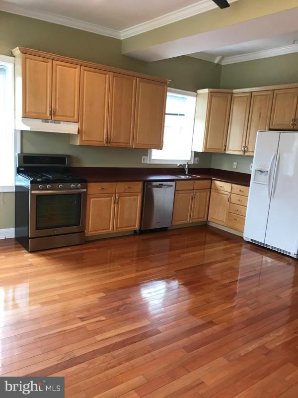3445 14th Street Northwest, Unit 2 Washington, DC 20010 - Photo 2 of 10 a kitchen with granite countertop wooden floors a stove and a microwave