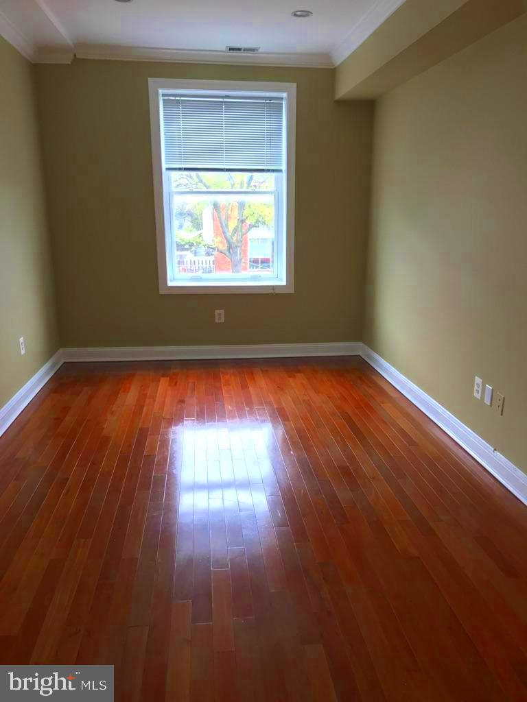 3445 14th Street Northwest, Unit 2 Washington, DC 20010 - Photo 3 of 10 a view of an empty room with wooden floor and a window
