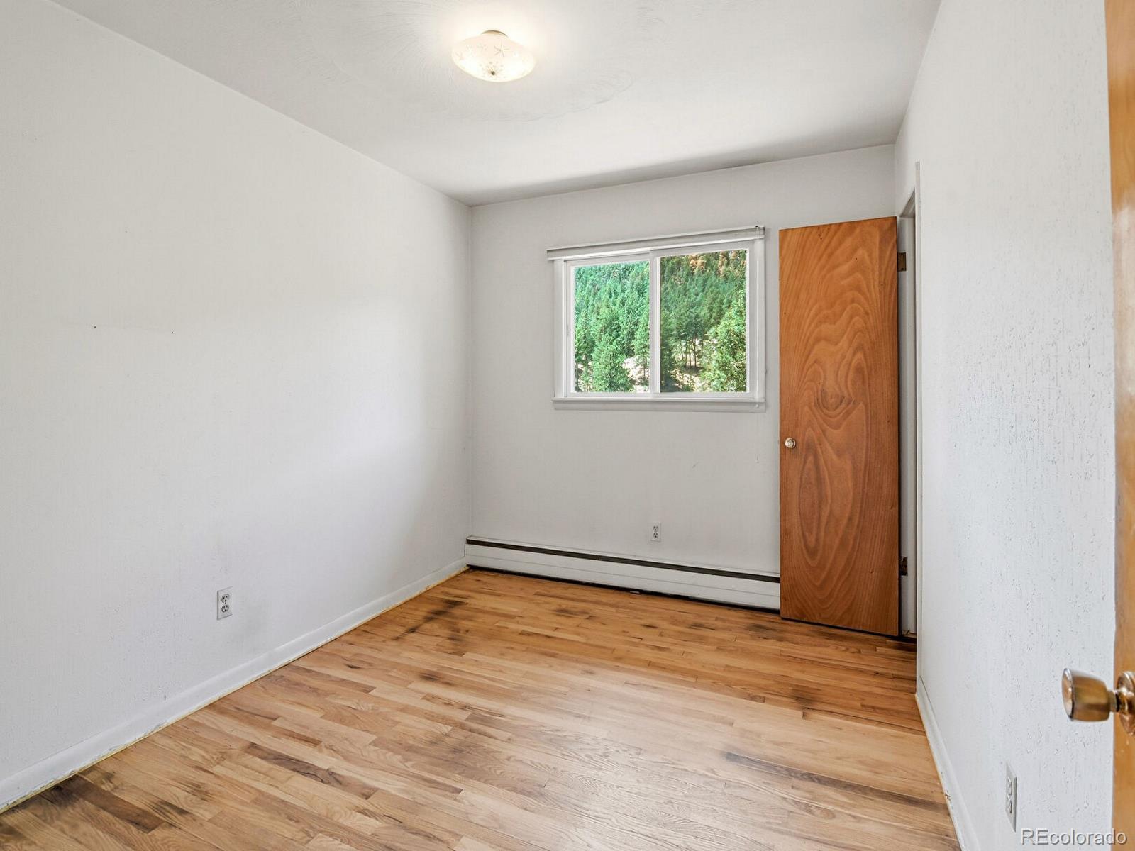 2830 Kerr Gulch Road Evergreen, CO 80439 - Photo 27 of 48 an empty room with wooden floor and windows