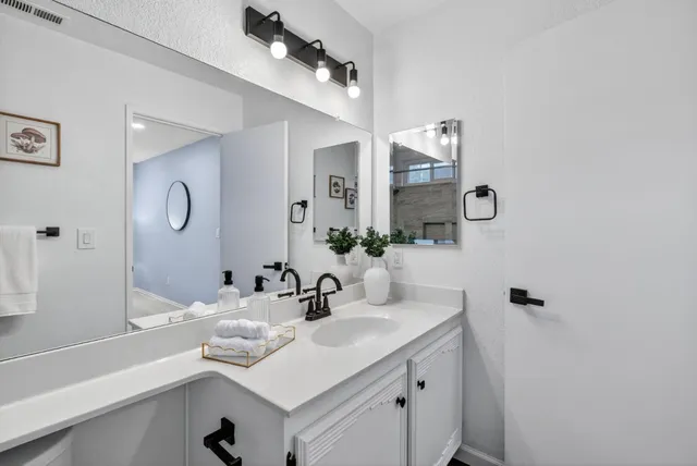 a bathroom with a sink vanity and mirror
