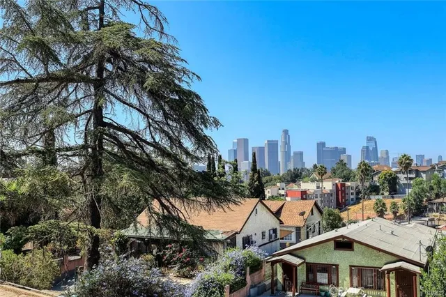 a view of a white house with a yard and plants