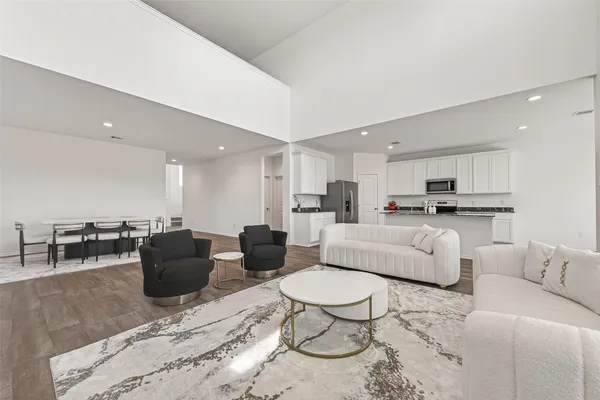 a living room with furniture and view of kitchen