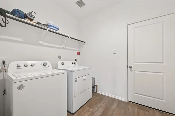 a view of washer and dryer with bathroom in the background