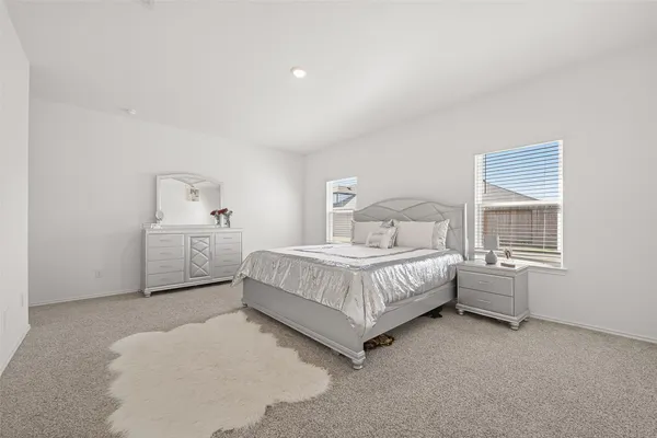 a spacious bedroom with a bed and a window