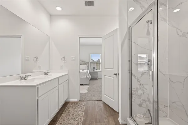 a bathroom with a double vanity sink mirror and shower