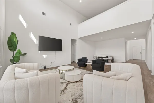 a living room with furniture a flat screen tv and a large window