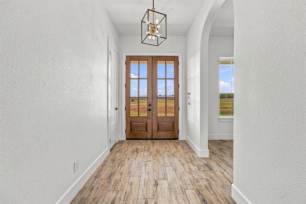 8140 Lavender Road Springtown, TX 76082 - Photo 5 of 40 Double glass-paneled entry doors, wood-finish flooring, recessed lighting, and a decorative archway