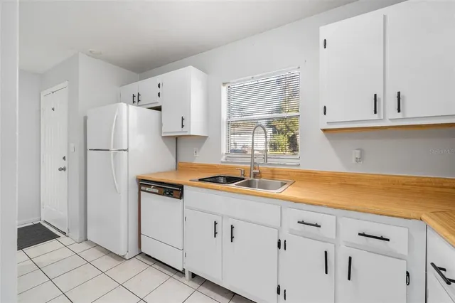 a kitchen with granite countertop white cabinets and white appliances