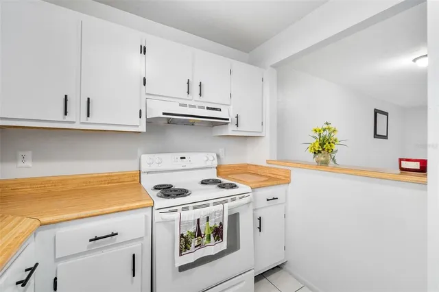 a kitchen with stainless steel appliances white cabinets and a stove a sink