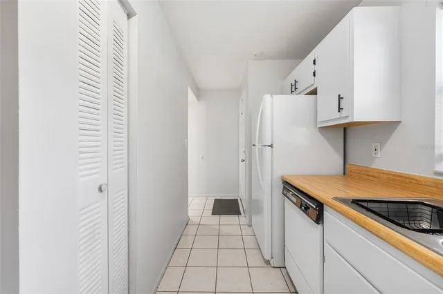 a kitchen with white cabinets and white appliances