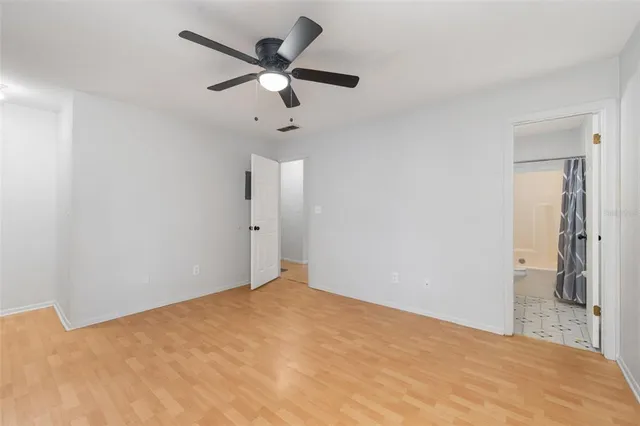 a view of a big room with wooden floor and a ceiling fan
