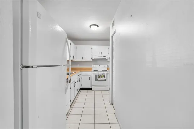 a kitchen with white cabinets and white appliances