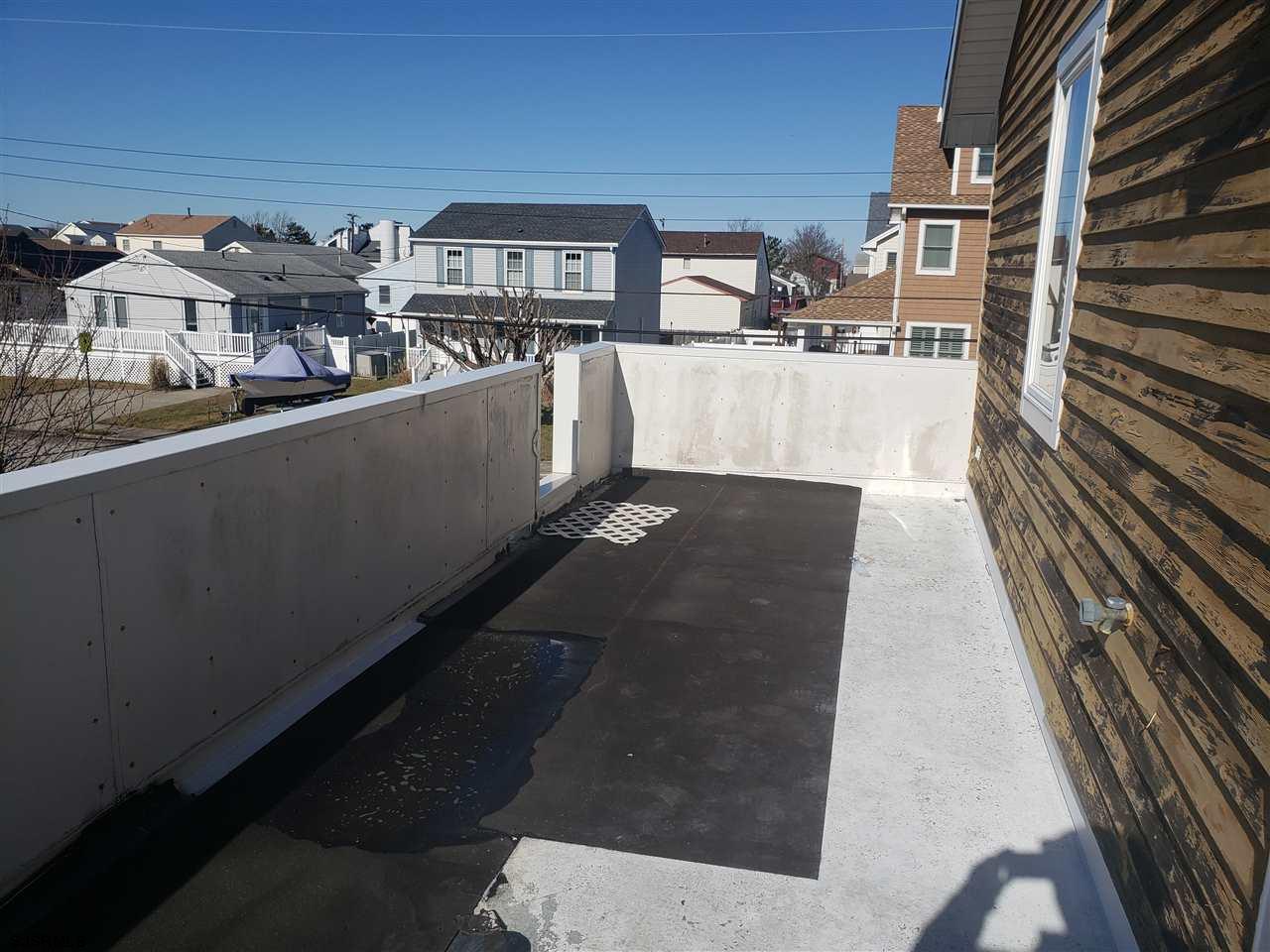 16 Vardon Road Brigantine, NJ 08203 - Photo 16 of 20 a kitchen with stainless steel appliances kitchen island granite countertop a refrigerator a stove and a sink with wooden cabinets