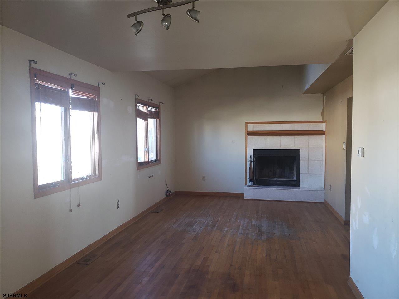16 Vardon Road Brigantine, NJ 08203 - Photo 7 of 20 an empty room with wooden floor fireplace and windows