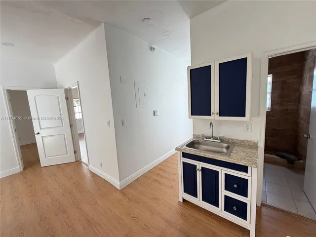 a view of kitchen with stainless steel appliances wooden floor and potted plant