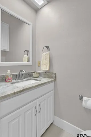 a bathroom with a granite countertop sink and a mirror