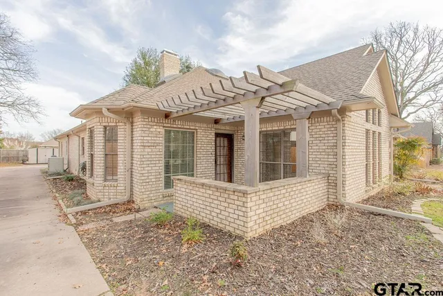 a view of a house with a small yard and wooden fence