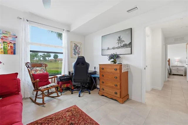 a view of a workspace with furniture and a window