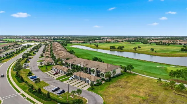 an aerial view of a city with lots of residential buildings and lake view