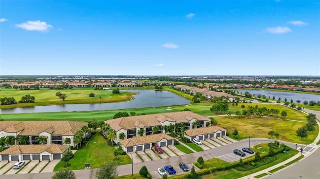 an aerial view of a residential houses with outdoor space and trees