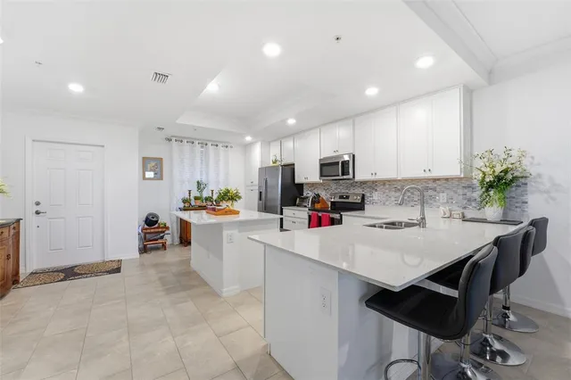 a kitchen with a sink a stove a refrigerator and cabinets