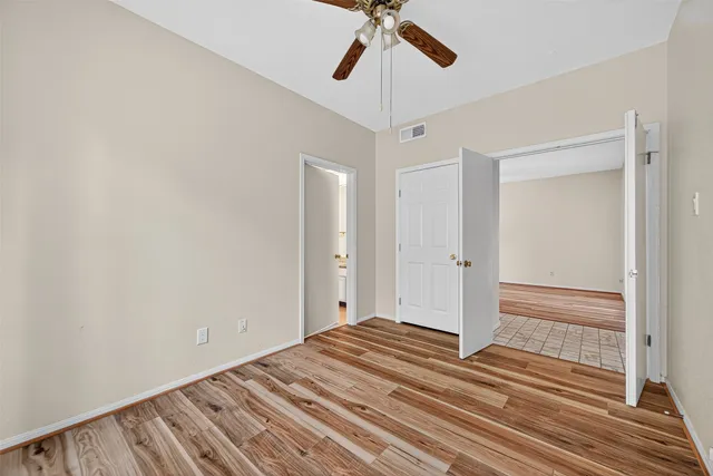 a view of a livingroom with wooden floor and ceiling fan