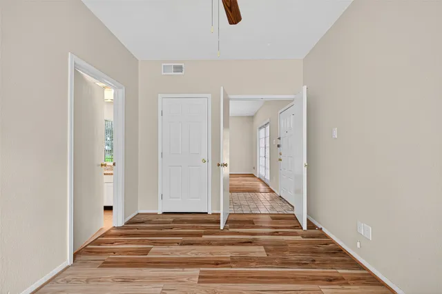 a view of a hallway with wooden floor and staircase