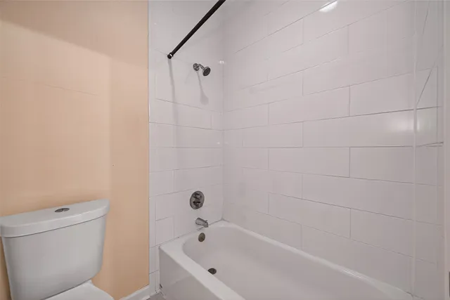 a white bath tub sitting next to a white toilet and a shower