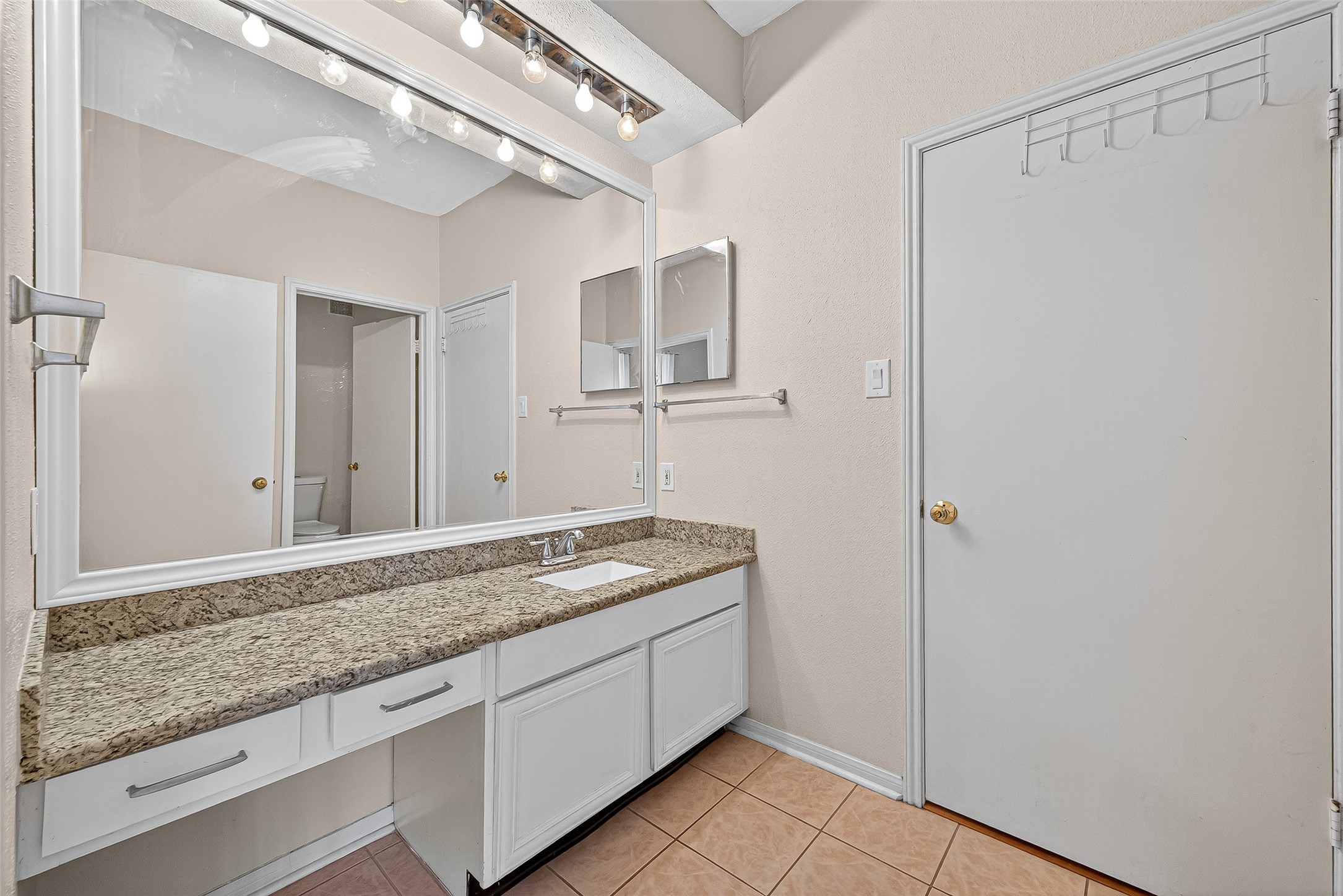 8055 Cambridge Street, Unit 89 Houston, TX 77054 - Photo 22 of 33 a bathroom with a granite countertop sink and a mirror