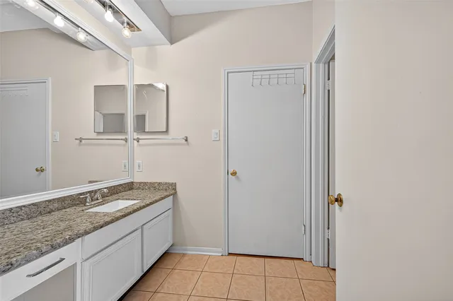 a bathroom with a granite countertop sink and a mirror
