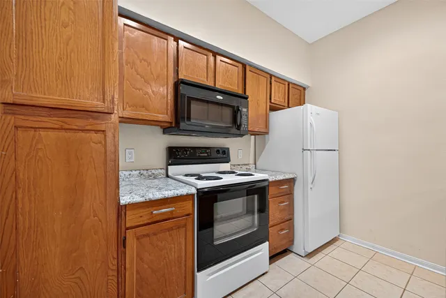 a kitchen with granite countertop cabinets stainless steel appliances and a window