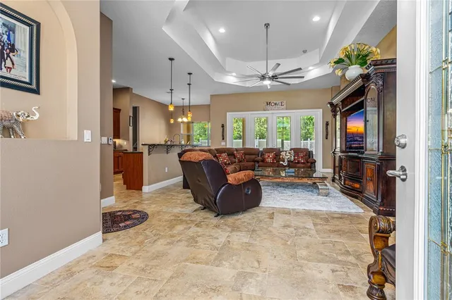 a living room with furniture a chandelier and a flat screen tv