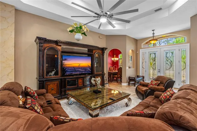 a living room with furniture a chandelier and a flat screen tv