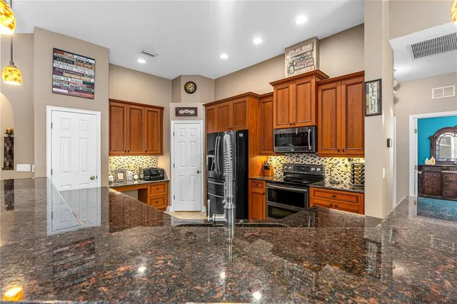 a kitchen with stainless steel appliances granite countertop a refrigerator and a stove