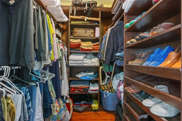 a view of walk in closet with clothes and shoes