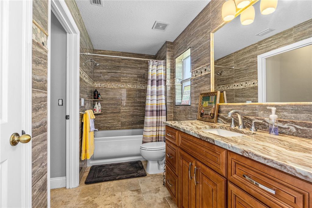 32 Seneca Path Palm Coast, FL 32164 - Photo 38 of 50 a bathroom with a granite countertop sink a toilet a mirror and shower