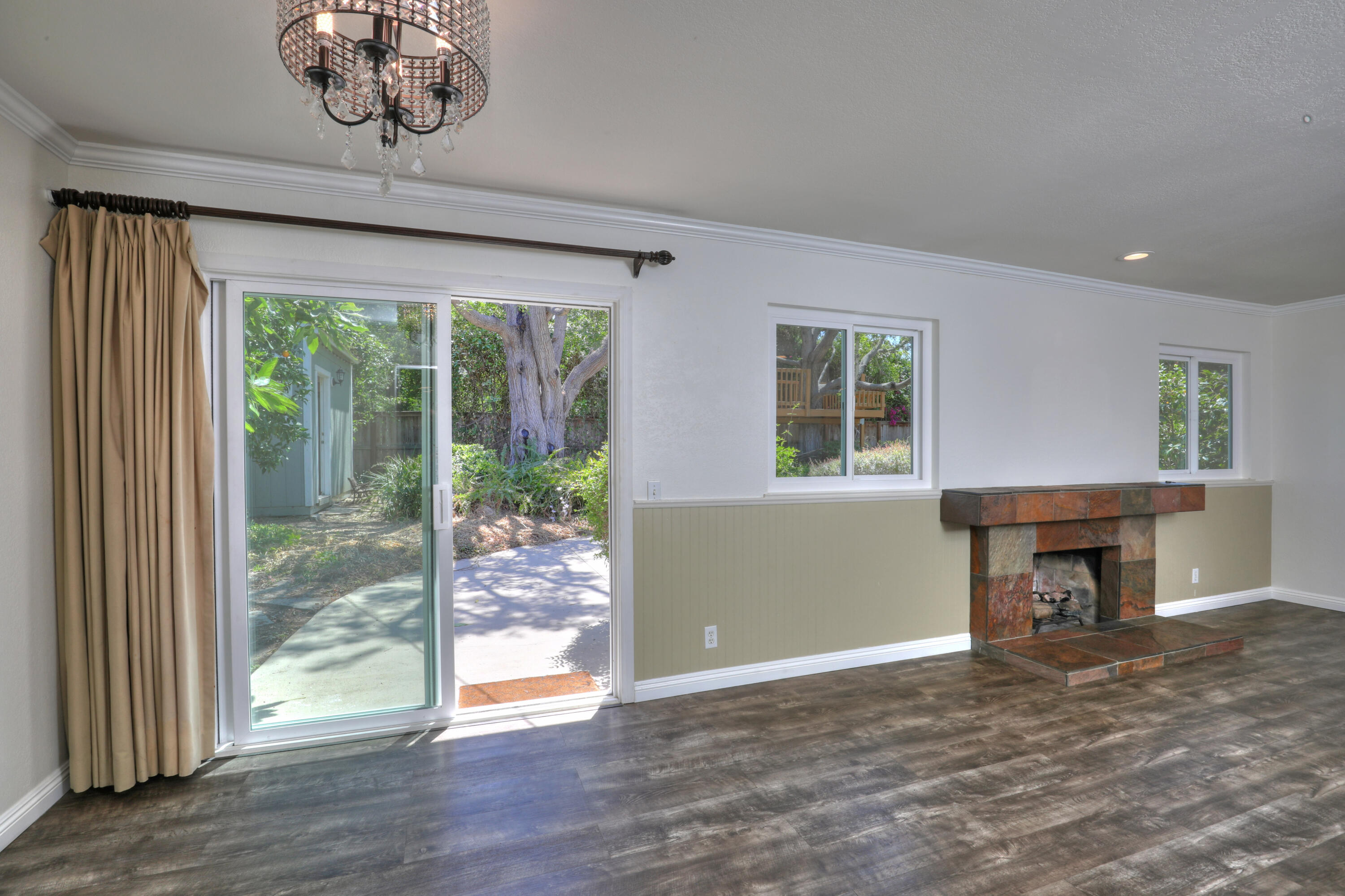488 Wakefield Road Goleta, CA 93117 - Photo 6 of 34 an empty room with wooden floor fireplace and windows