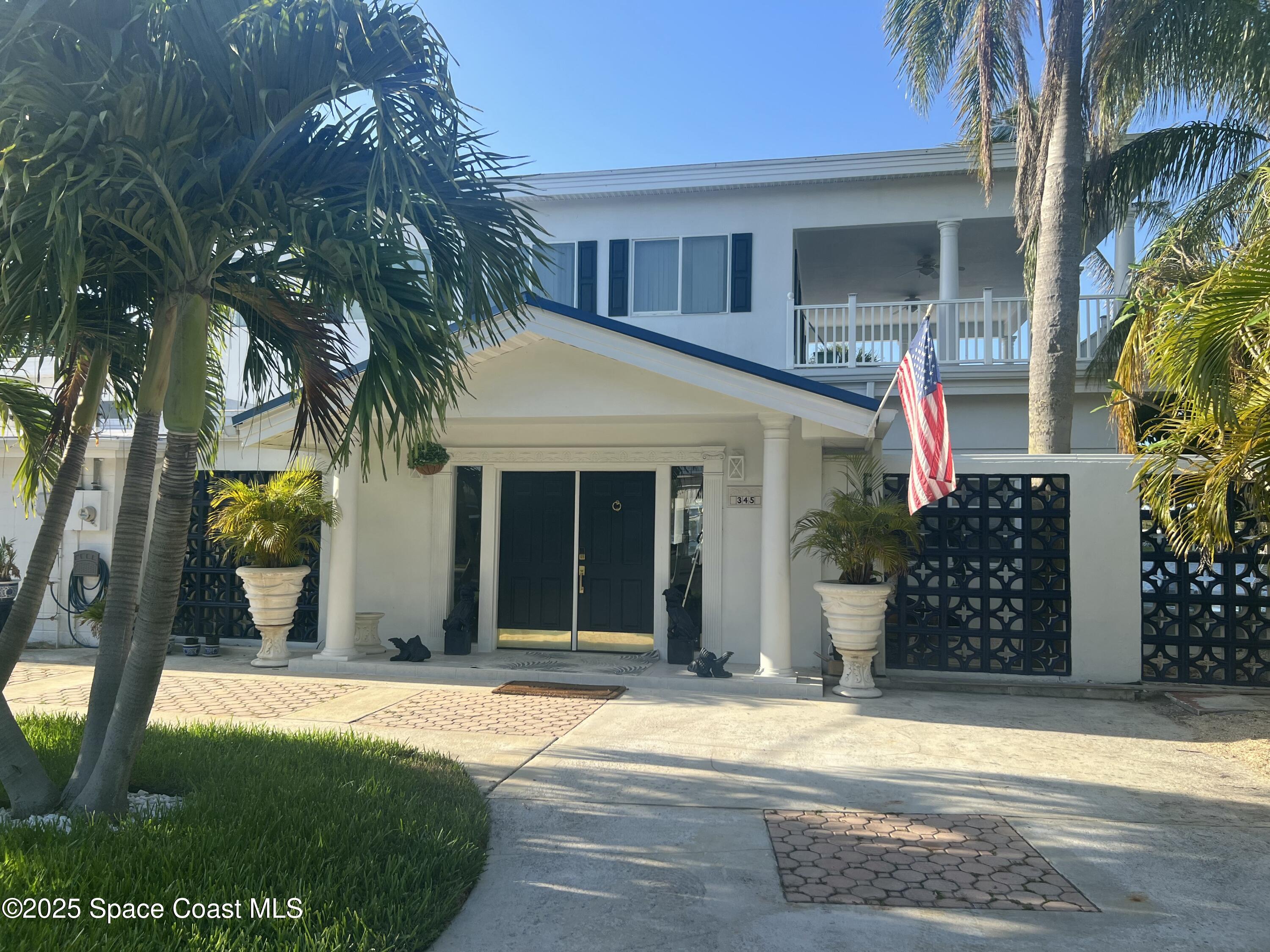 345 South Point Court Satellite Beach, FL 32937 - Photo 1 of 27 a view of a house with a yard and palm trees