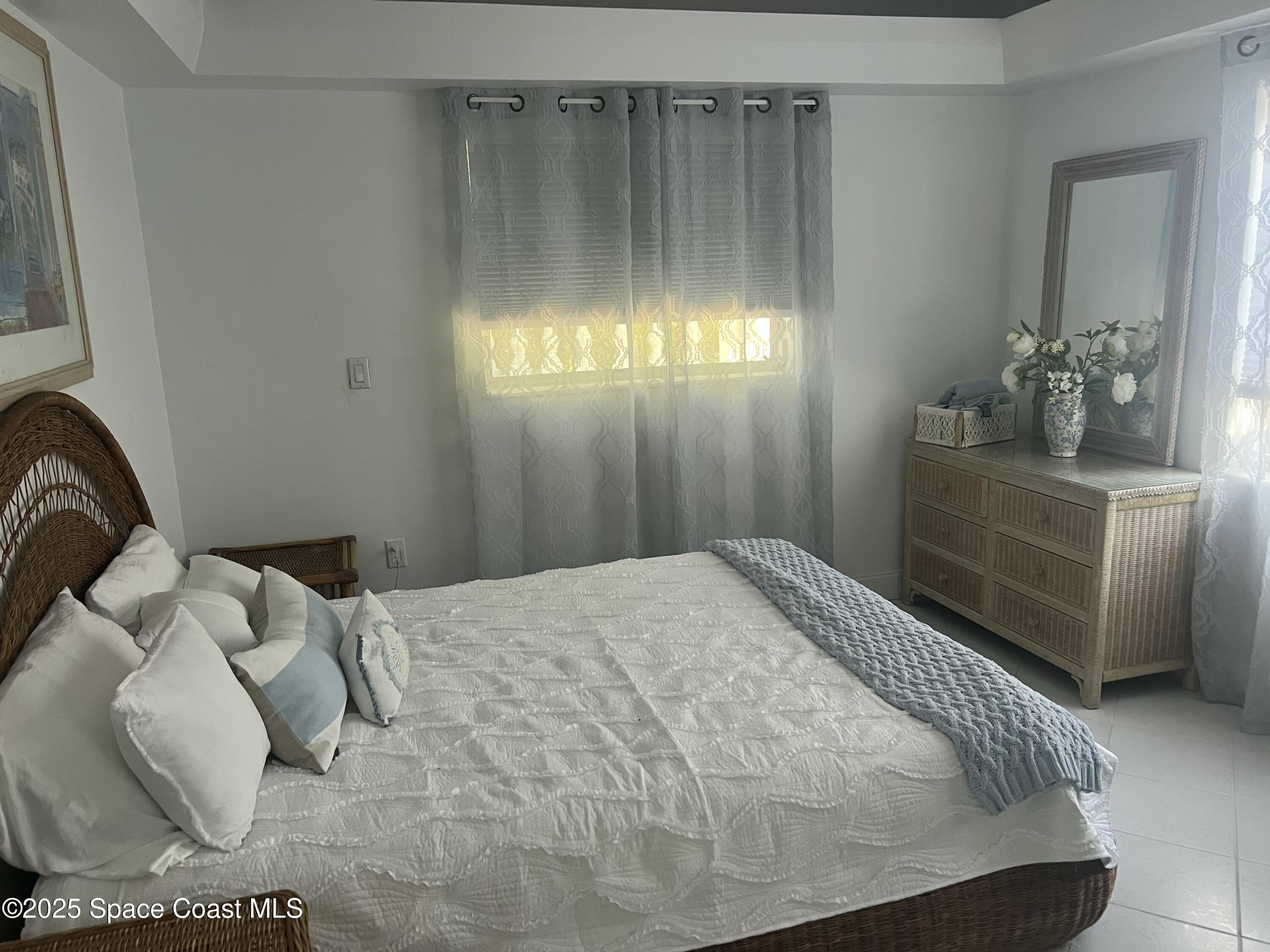 345 South Point Court Satellite Beach, FL 32937 - Photo 17 of 27 a bedroom with a bed and a chandelier