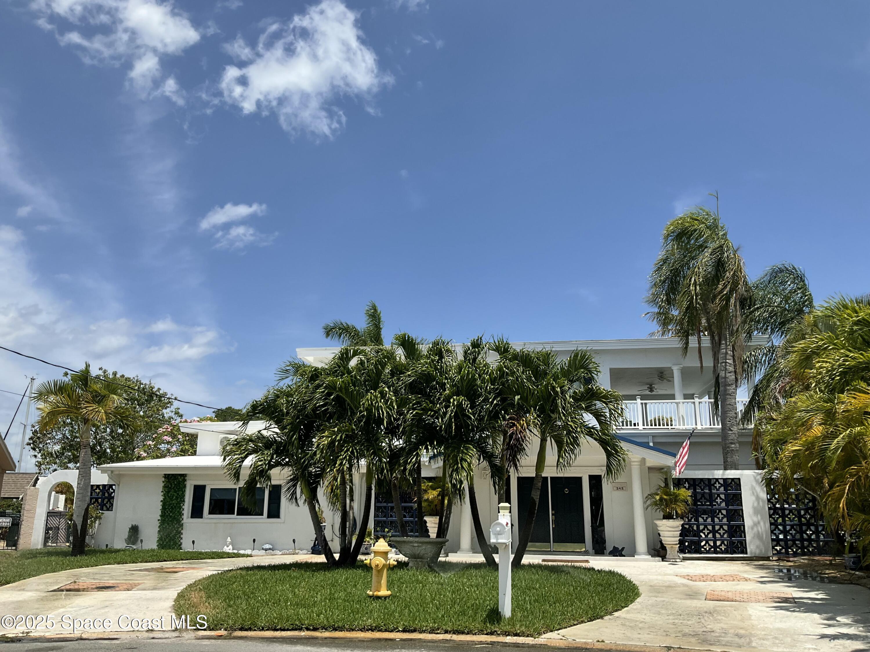 345 South Point Court Satellite Beach, FL 32937 - Photo 2 of 27 a front view of a house with a yard and a garage
