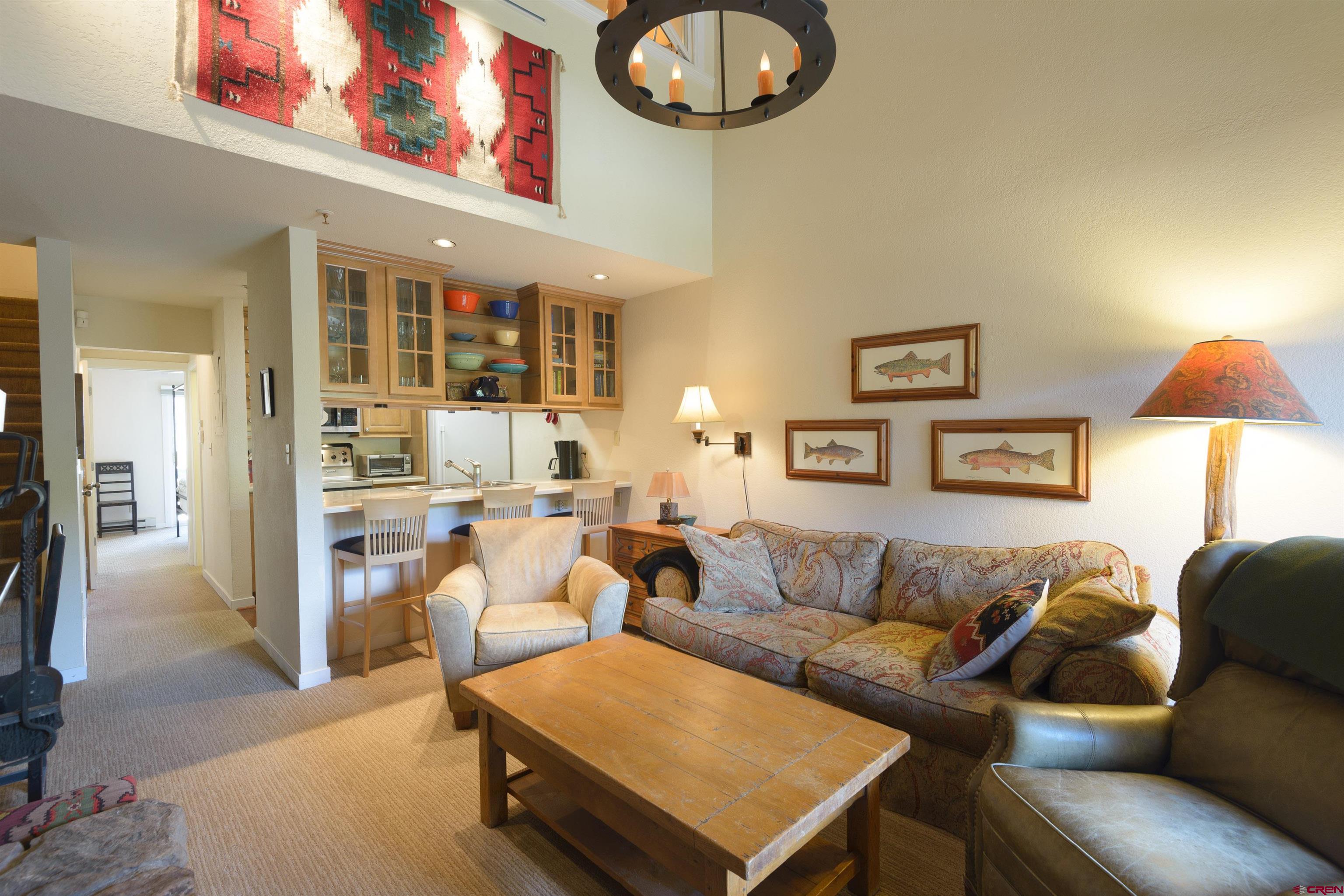 12 Snowmass Road, Unit 416 Crested Butte, CO 81225 - Photo 14 of 35 a living room with furniture a lamp and a chandelier