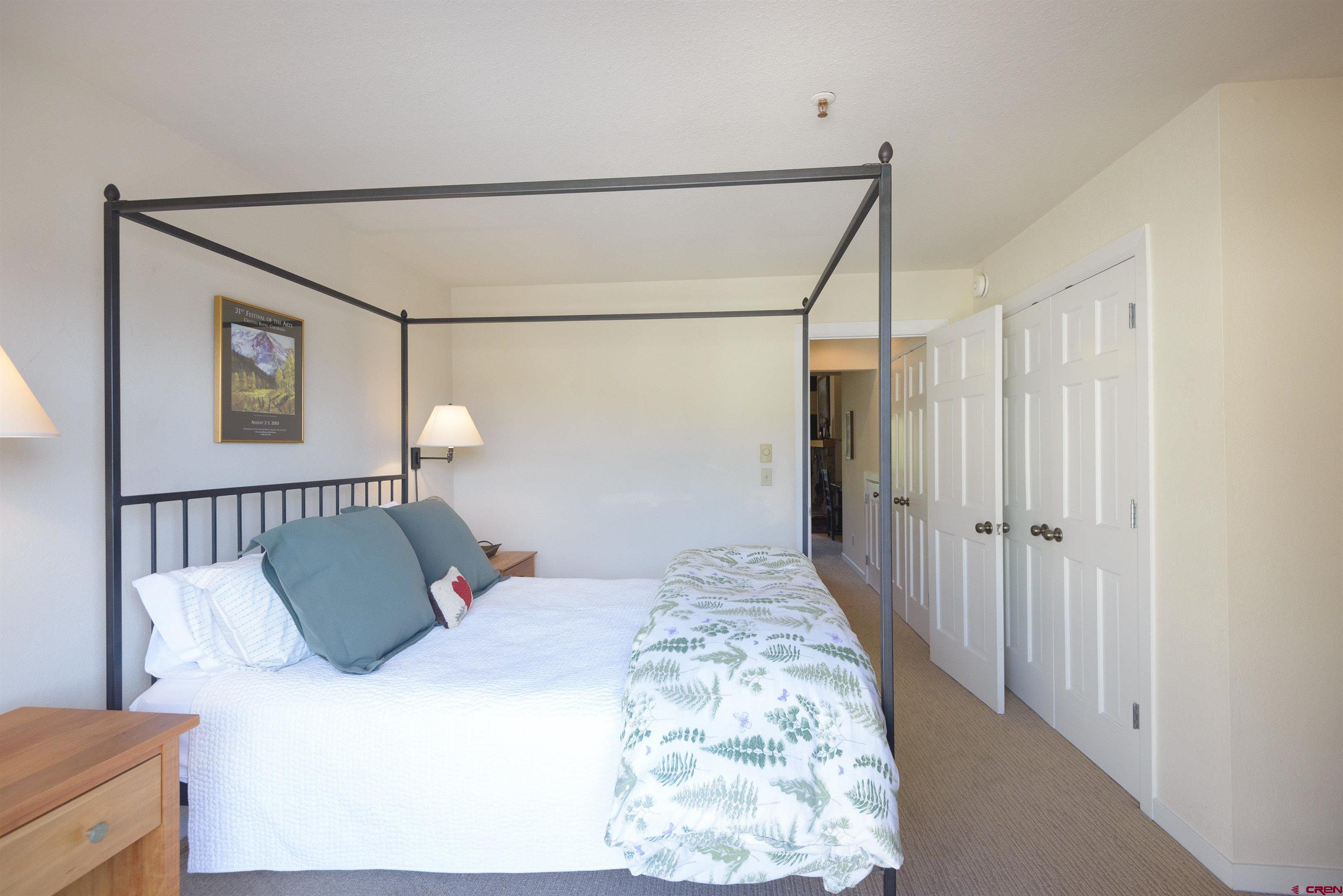 12 Snowmass Road, Unit 416 Crested Butte, CO 81225 - Photo 16 of 35 a bedroom with a bed and a chandelier